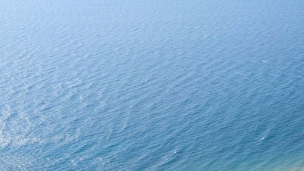 A kék tengervíz felszínén lévő vezetékek. - Fotó, kép