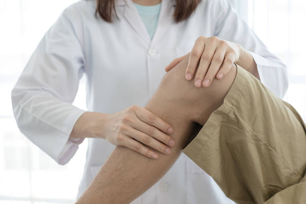 Männliche Patienten konsultierten Physiotherapeuten mit Kniebeschwerden zur Untersuchung und Behandlung in Reha-Zentren. Reha-Physiotherapiekonzept. - Foto, Bild