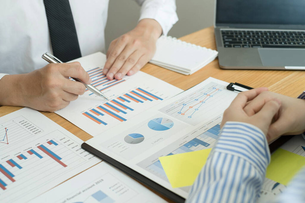 Zwei Unternehmensführer sprechen über Diagramme, Finanzgrafiken, die Ergebnisse zeigen, analysieren und berechnen Planungsstrategien, Unternehmenserfolg aufbauende Prozesse. - Foto, Bild
