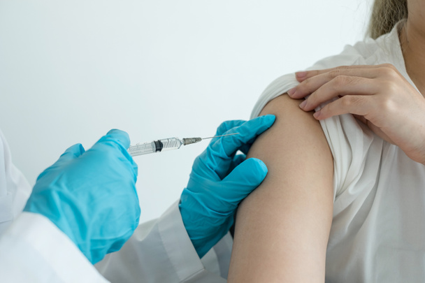 Vrouwelijke artsen gevaccineerd met injectiespuiten om epidemieën in ziekenhuizen, gezondheidszorg en medische concepten te voorkomen. - Foto, afbeelding
