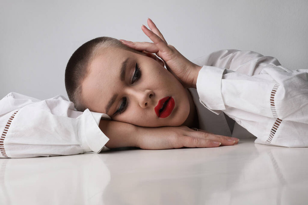 Headshot of young bald woman with make-up posing at studio. - Photo, Image
