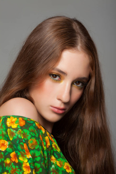 Beautiful woman with stylish green yellow makeup in dress with with floral pattern - Foto, Imagem