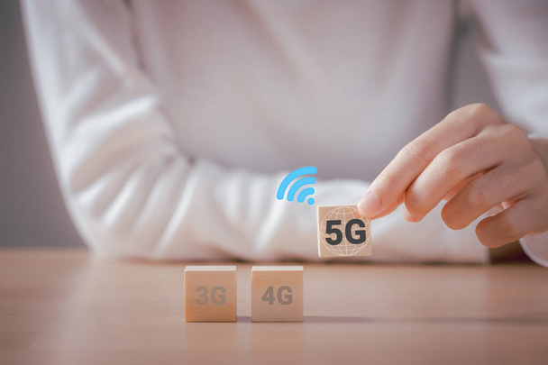 La mujer elige el bloque de madera 5G, símbolo del cambio de 3G, 4G a 5G, tecnología de conexión de red concepto global futuro. - Foto, imagen