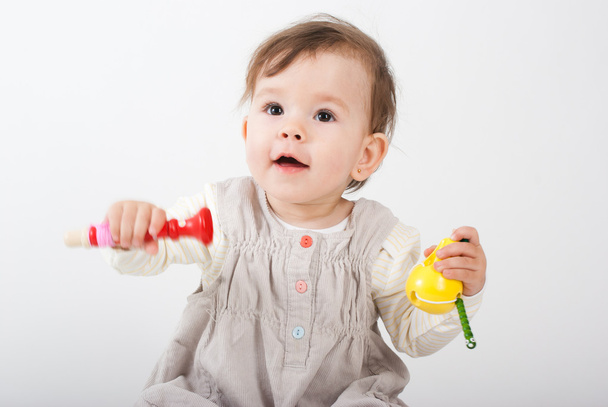 The little girl plays with wooden toys a white background - Foto, afbeelding