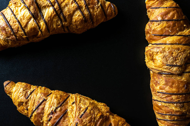 Cesta de croissant. Pan recién horneado o croissants de pastelería francesa con mermelada en mesa de panadería negra. Sabrosos croissants con espacio para copias, planas - Foto, imagen