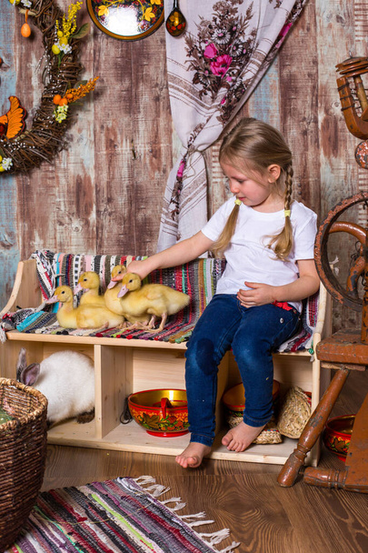 onnellinen pieni tyttö pelataan söpö pörröinen pääsiäinen ankanpoikasia - Valokuva, kuva