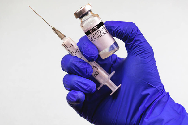 Концепция вакцинации, флакон вакцины COVID-19 и медицинский шприц в руке врача, больничное прошлое - Фото, изображение