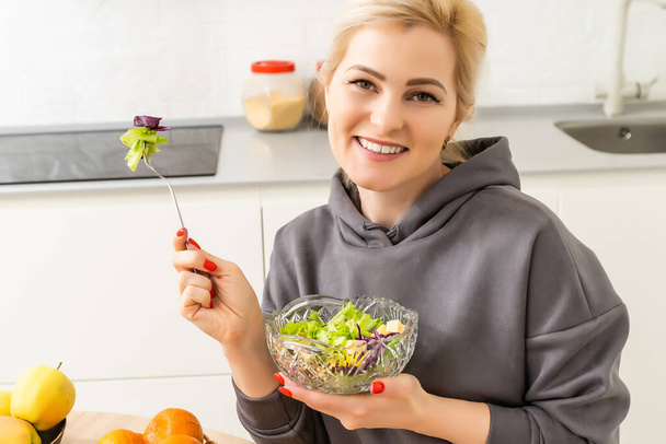 healthy eating, dieting and people concept - close up of young woman eating vegetable salad at home - Photo, Image