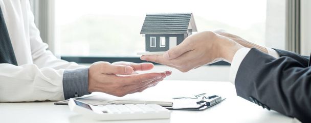 Der Immobilienmakler übergibt das Haus nach Abschluss des Mietvertrages und des formellen Abschlusses der Hausversicherung an den Kunden des neuen Eigentümers. Miet- und Versicherungskonzepte. - Foto, Bild