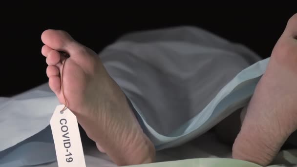 Une mort covid-19 sur le lit de la morgue avec le tag - Séquence, vidéo