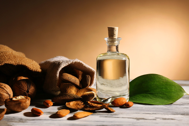 Walnut oil and nuts on wooden table - Valokuva, kuva