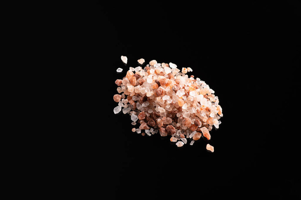 Large pink himalayan salt on black background, top view, empty space for text - Foto, afbeelding