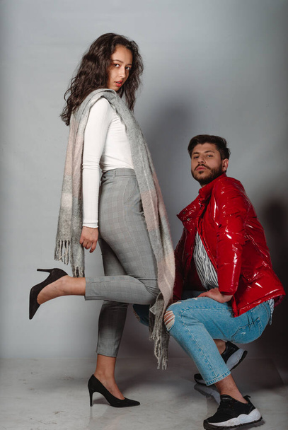 Pair of male and female models in modern clothes posing side by side against white background - Photo, Image