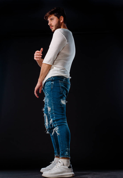 Studio body shot van een trendy jongeman in moderne stijl kleding - Foto, afbeelding