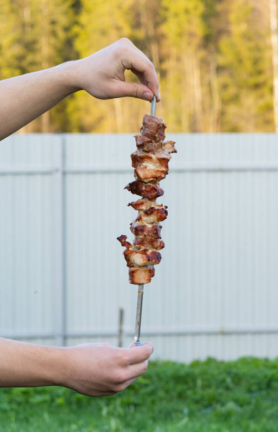Delizioso shish kebab su uno spiedo nelle tue mani.  - Foto, immagini