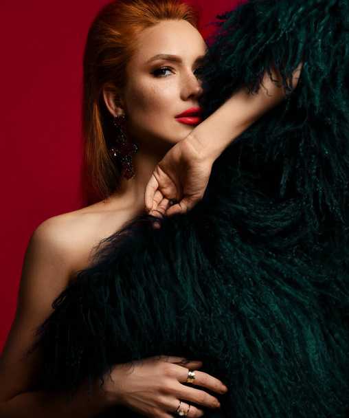 Portrait of excited seductive rich sensual young red-haired woman standing naked covering herself with luxury fur coat - Φωτογραφία, εικόνα