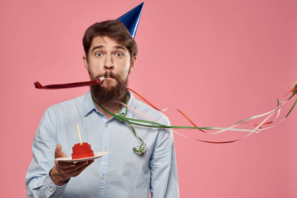 Barbudo hombre con pastel en rosa fondo cumpleaños fiesta corporativa emociones modelo soledad - Foto, imagen