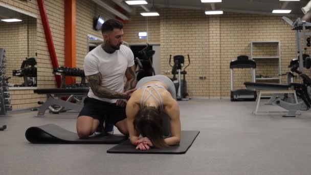Αθλητική προπόνηση με προσωπικό γυμναστή στο γυμναστήριο - Πλάνα, βίντεο