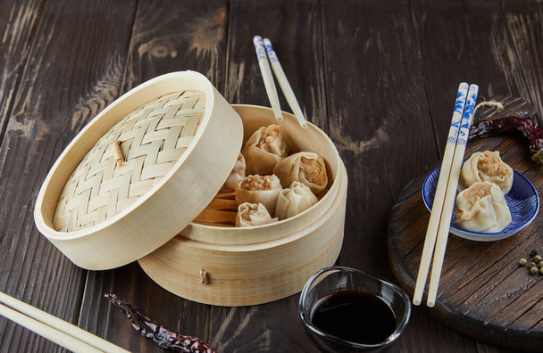 Shumai shaomai kínai húsgombóc párolt étel bambuszgőzös dobozban. Név dim sum - Fotó, kép