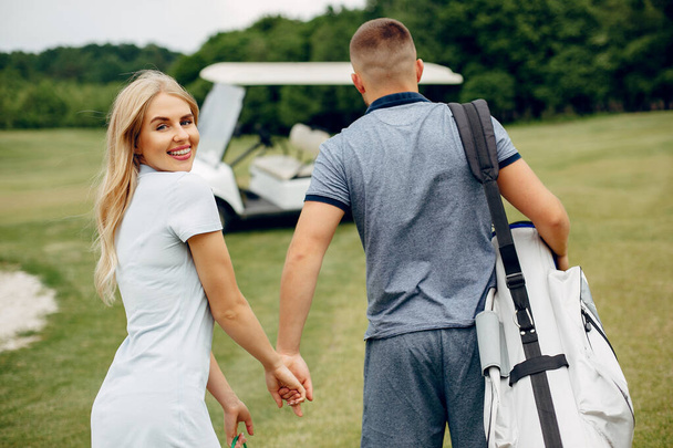 Beautiful couple playing golf on a golf course - Photo, Image