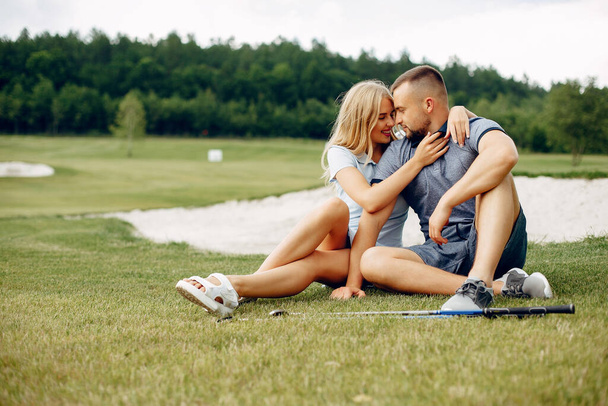 Beautiful couple playing golf on a golf course - Photo, image