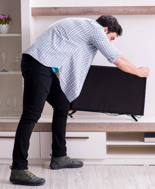 Muž se snaží opravit rozbitou televizi - Fotografie, Obrázek