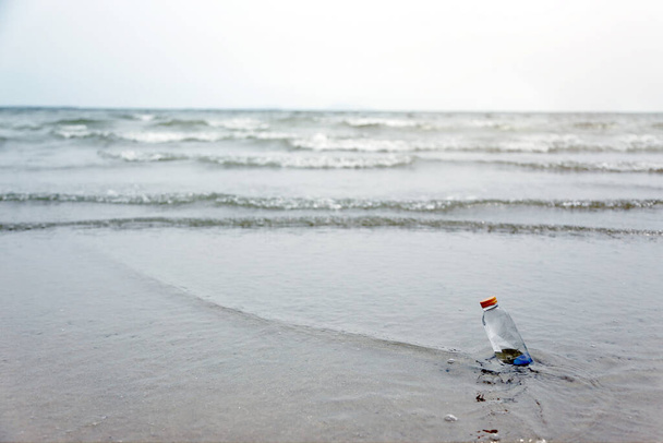 пресная вода в бутылке на песчаном пляже океана для жилой концепции - Фото, изображение