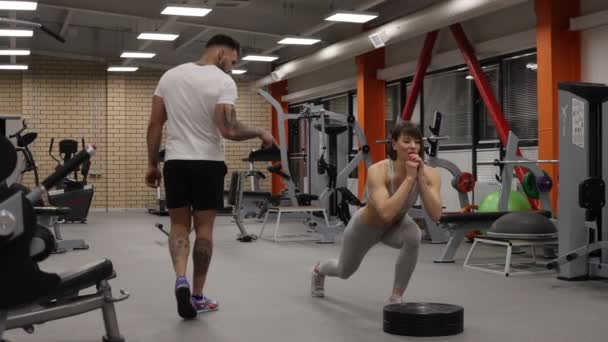 Sportswoman training with personal instructor in gym - Footage, Video