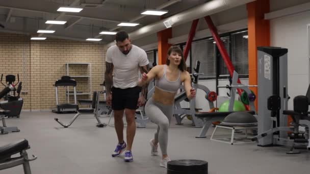 Sportswoman training with personal instructor in gym - Footage, Video