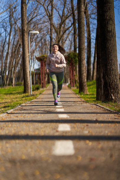 Size plus woman running in the park in the spring time - Foto, Bild