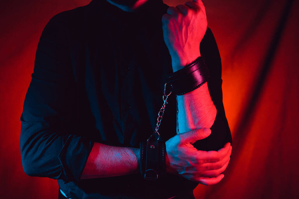 Мужские руки, закованные в кожаные наручники для секса БДСМ. подчинение и доминирование - Фото, изображение