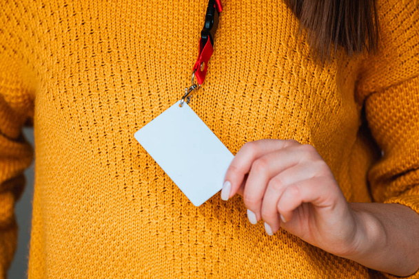 Mulher segurando crachá nome tag com espaço em branco simular - Foto, Imagem