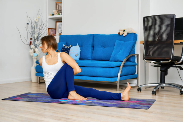 Full length portrait of young woman doing yoga marichi pose - Photo, Image