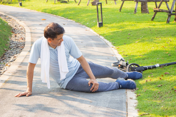 Старые азиаты страдают от физической боли. старший мужчина пострадал от боли в ноге в аварии. - Фото, изображение