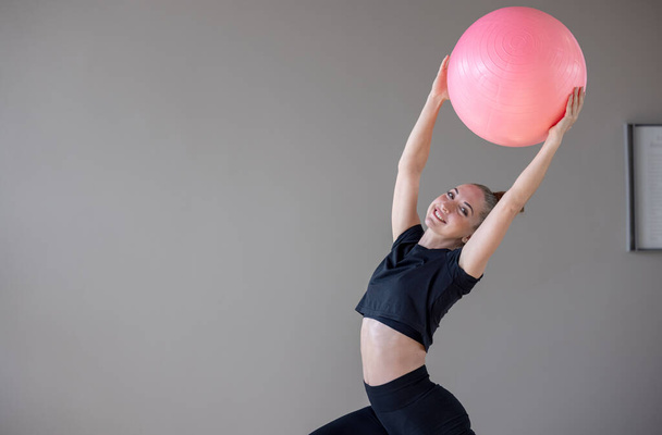 Krásná žena trénink pilates na fitness míč v tělocvičně, Ženy na cvičení s fitness míčem - Fotografie, Obrázek