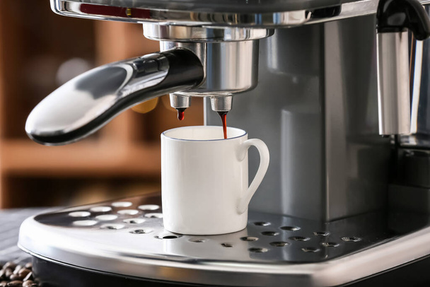 Kafede bir fincan sıcak espresso ile modern kahve makinesi. - Fotoğraf, Görsel