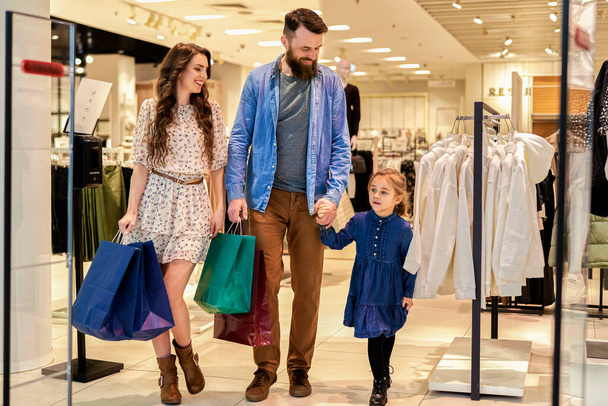 Familia feliz paseando en el centro comercial                                - Foto, imagen
