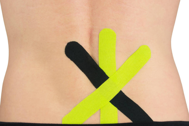 on the back of the back, a kinesio tape is pasted to facilitate the relief of lower back pain - Foto, Bild