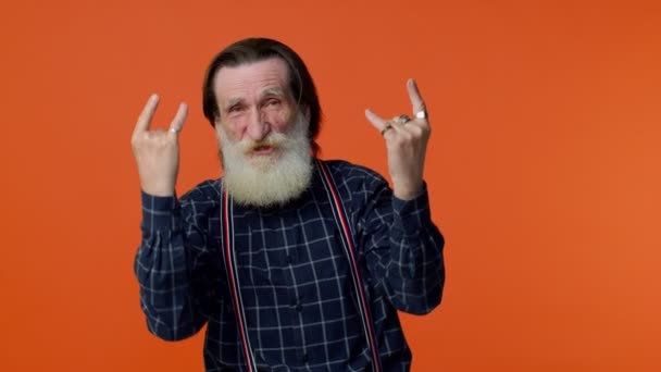 Чрезвычайно радостный сумасшедший пожилой мужчина показывает рок-н-ролл жест руками, крутой знак, танцы - Кадры, видео