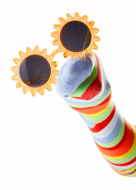 Boldog színes zokni báb visel napszemüveg elszigetelt fehér háttér - Fotó, kép