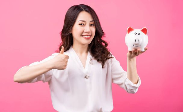 Asijské podnikatelka držení prasátko v ruce, spoření peníze koncept - Fotografie, Obrázek