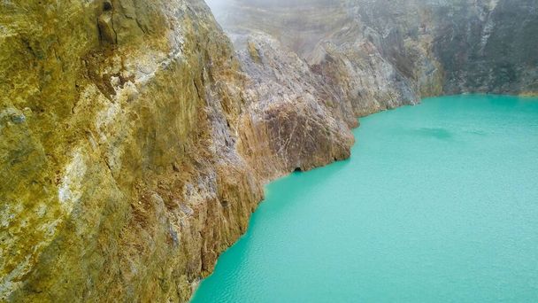 Uma vista de perto da superfície do Lago Alapolo e da parede da cratera. imagens aéreas de lagos mulitcolored Kelimutu, Indonésia. Parque Nacional e UNECSO protege incrível cor mudando lagos e paisagens - Foto, Imagem