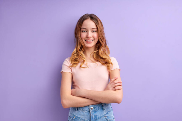 Teenager caucasian girl isolated on purple background keeping arms crossed in frontal position - Φωτογραφία, εικόνα