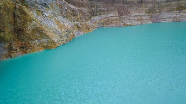A close up view of the surface of Lake Alapolo and the crater wall. aerial footage of Kelimutu mulitcolored lakes, Indonesia. National Park and UNECSO protects amazing color changing lakes and scenery - Photo, Image
