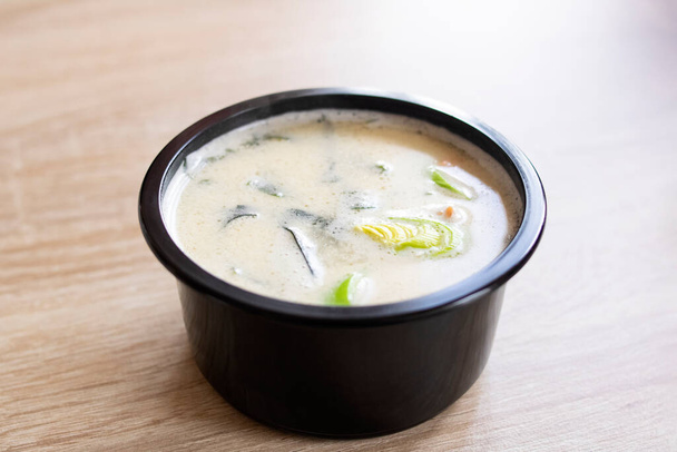 Sýrová polévka v černé misce na dřevěném stole - Fotografie, Obrázek