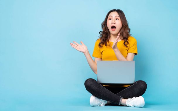 Young girl sitting using laptop with expressions and gestures on background - Foto, Imagem