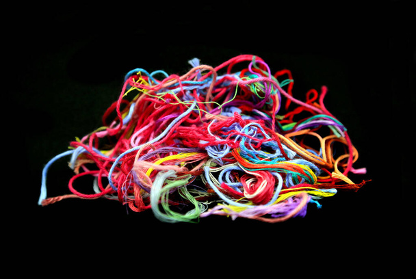 Bola de fios de algodão emaranhado multicolorido e fios para bordado close-up no fundo preto - Foto, Imagem