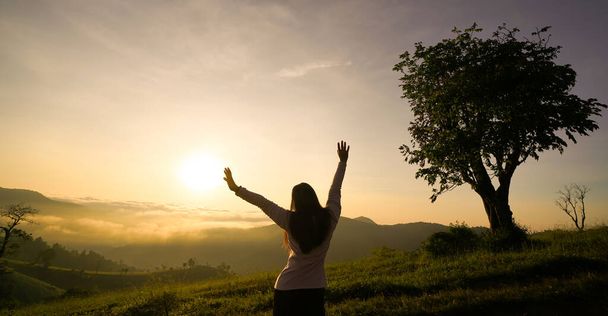 Boldog nő élvezi az életet napkeltekor a hegyekben - Fotó, kép