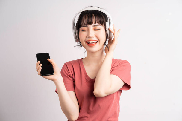 Young Asian woman using wireless headphone to listening music - Fotografie, Obrázek