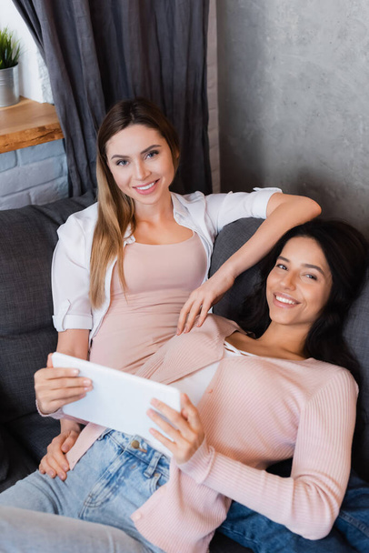 happy lesbian couple watching movie on digital tablet at home  - Foto, imagen